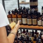 A customer choosing an item among organic cosmetic bottled products.