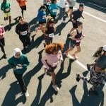 Aerial view of a diverse group of participants running in an organized outdoor race. 