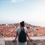 A young tourist looking over red-brownish roofs from Old Town in Dubrovnik, Croatia.
