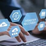 Businessman typing over a keyboard illustrated with conceptual graphics for a cyber disaster recovery system.