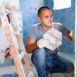Man installing bathroom tile.