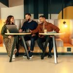 A group of young entrepreneurs working together in a lobby.