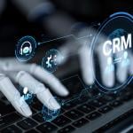 A robot enhancing CRM automation analytics and tools with artificial intelligence from a laptop.