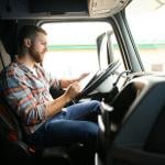 A driver checking cargo documents inside a truck before transportation.