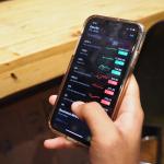 A person checking the stock market from an iPhone.
