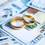 A pair of wedding rings on top of US banknotes.