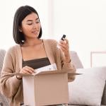 A young woman unboxing a package of makeup delivery.