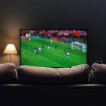 A football match displayed from a smart TV at a home's living room.