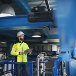 An engineer checking pipes inside an industrial factory.