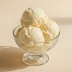 Premium vanilla ice cream scoops placed in a glass bowl. 