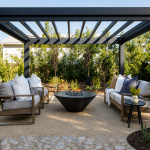 A modern black aluminum pergola structure with a contemporary outdoor lounge area.