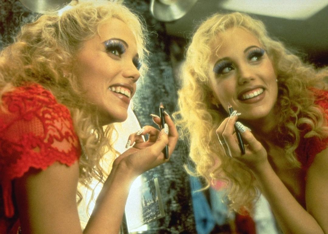 Elizabeth Berkley puts on makeup in a mirror in "Showgirls"