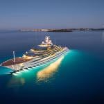 A yacht on the water lit up at night.