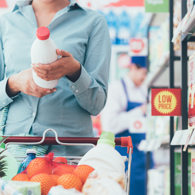 A person reading a food label in a supermarket.