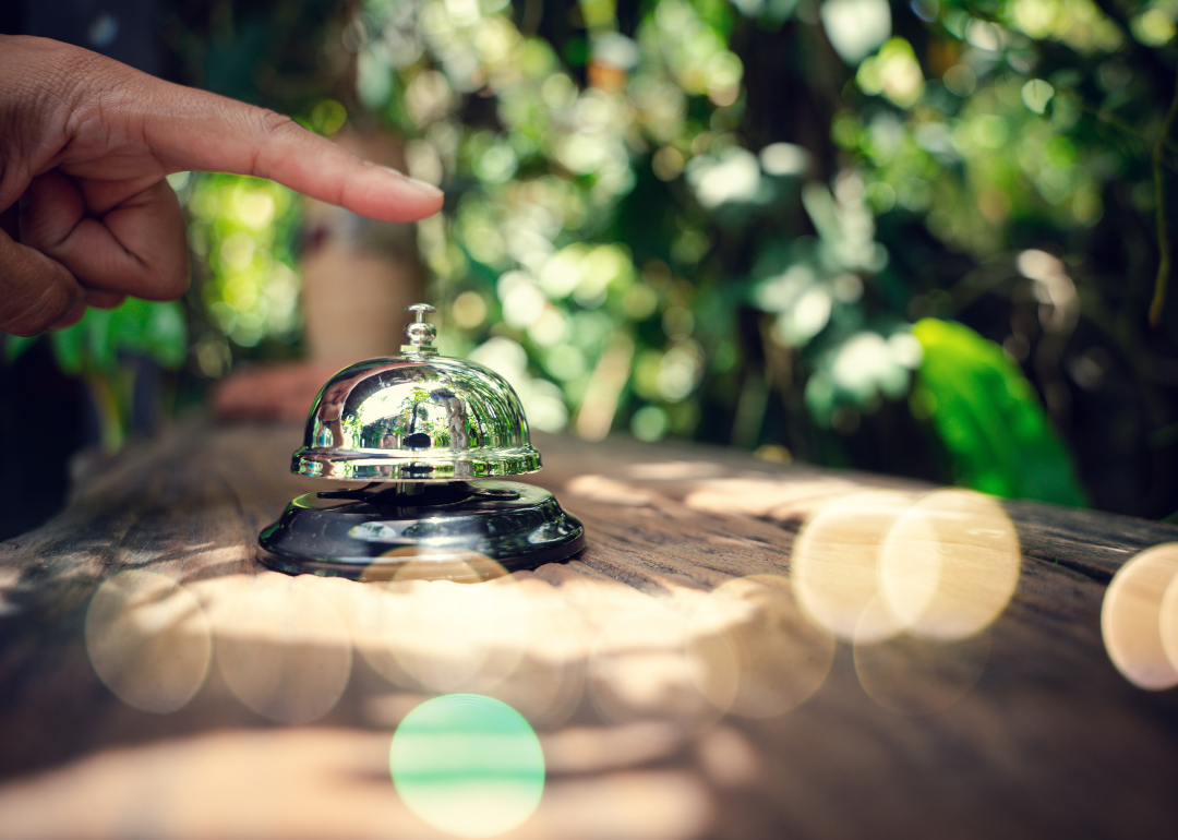 Hand ringing service bell with green background