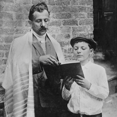 A vintage photo of a father and son reading a book. 