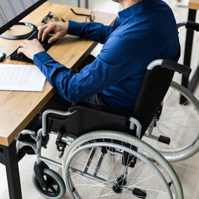 Person in wheelchair working at desk.
