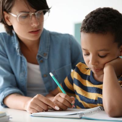 Teacher helping child with assignment.