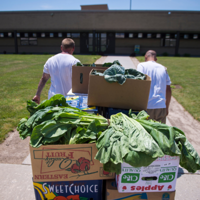 Inmates carry boxes of produce at correctional institute