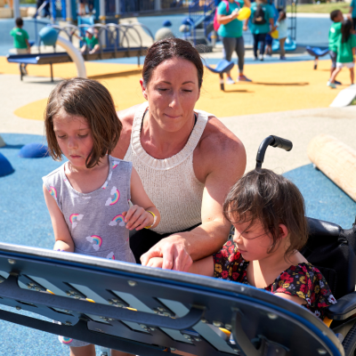 Woman and children at a universally accessible playground