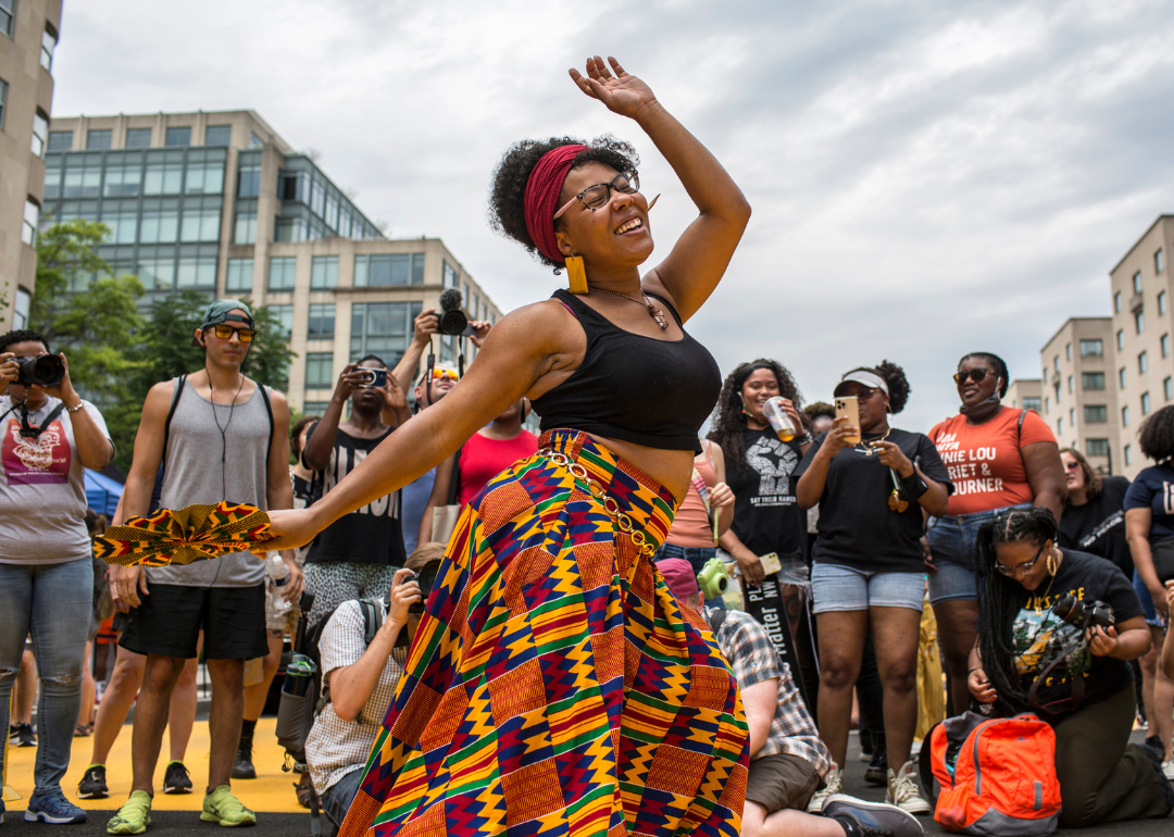 A Black woman dances to live music as she celebrates Juneteenth.