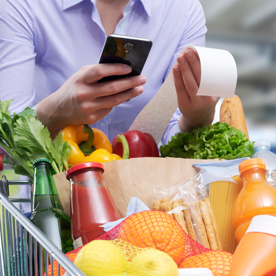 Woman checking the grocery receipt using her smartphone.