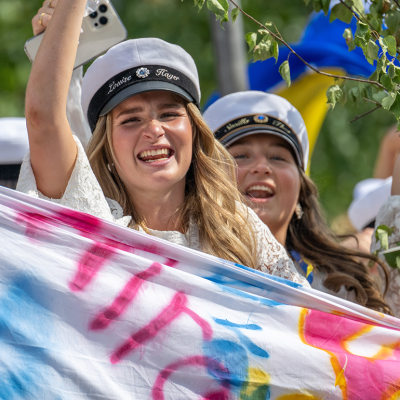 Swedish students celebrating in graduation parade.