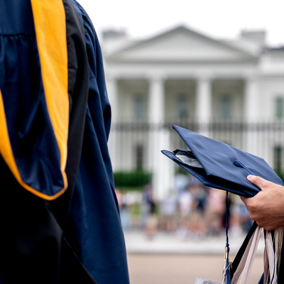 Students wear graduation gowns outside of the White House.