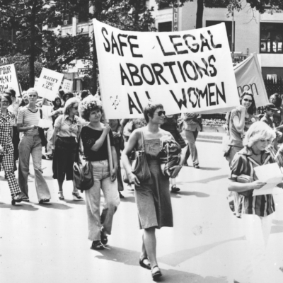 Women in a demonstration with ‘Safe Legal Abortions for all Women’ Sign