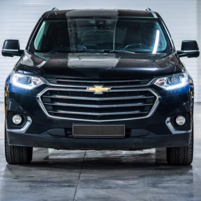 Chevrolet Traverse II front view with headlights on.