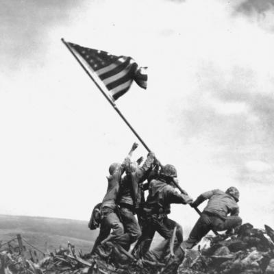Members of the United States Marine Corps 5th Division raise an American flag on Mount Suribachi during the Battle of Iwo Jima. 