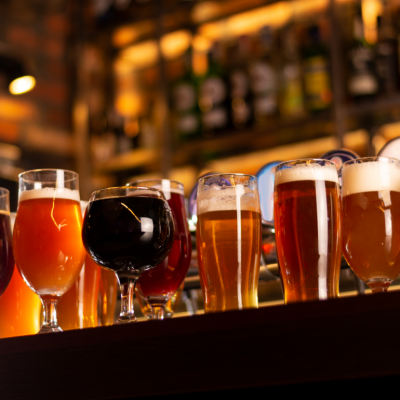 Selection of craft beers in different shaped glasses sitting on a bar.