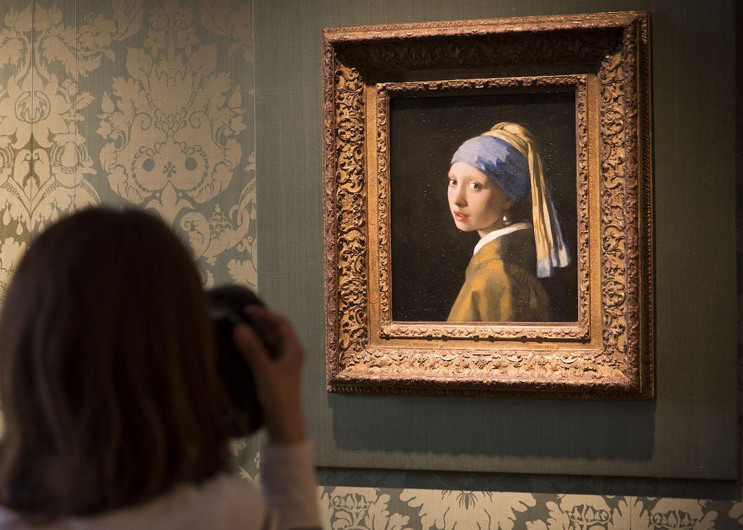 A journalist takes a photo of Johannes Vermeer's 'Girl with a Pearl Earring' (c 1665) in the Vermeer Room in the Mauritshuis Museum on June 20, 2014 in The Hague, Netherlands.