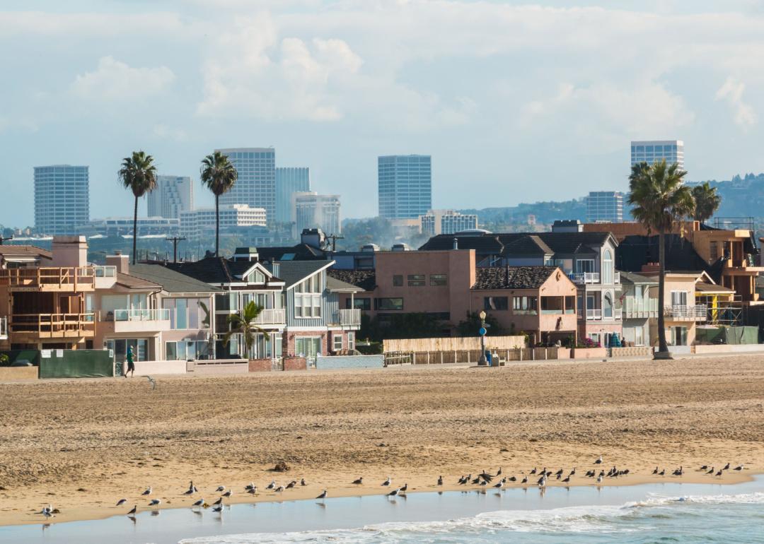 The coastline of Newport Beach, California on a hazy sunny morning with the Irvine city skyline in the distance.