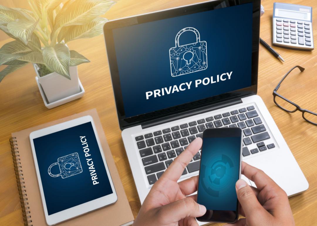Privacy policy signs appear on the screens of a laptop, tablet and phone