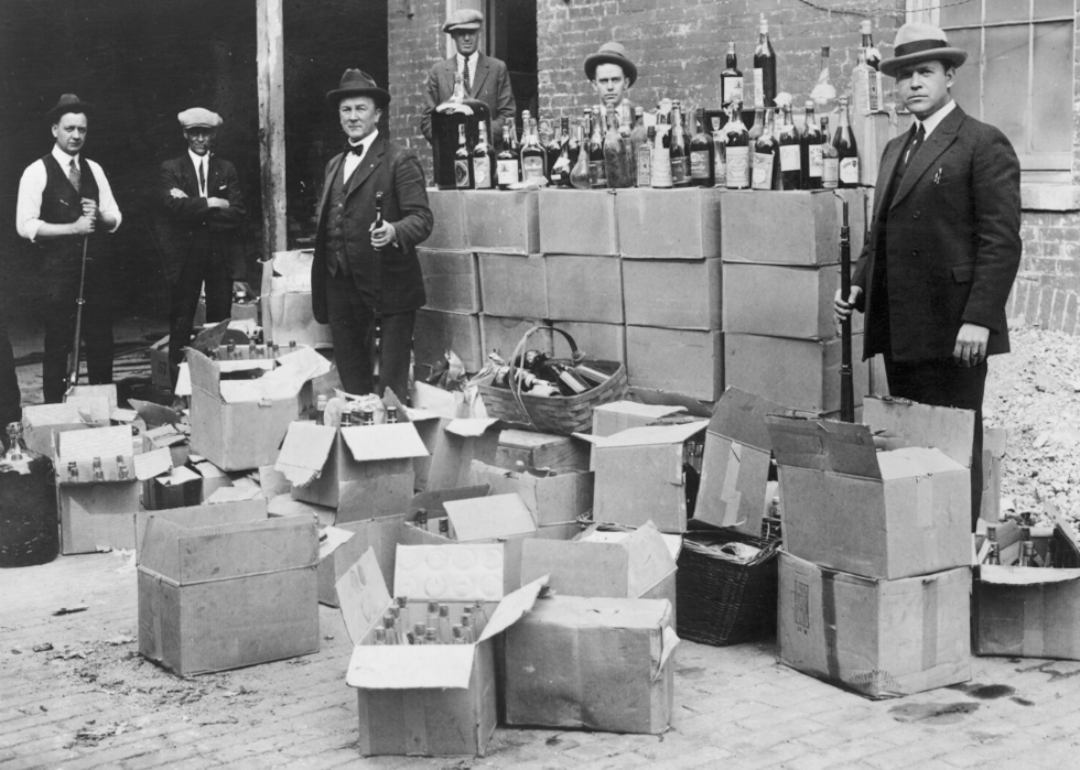Bootleggers stand with boxes of alcohol in the 1920s.