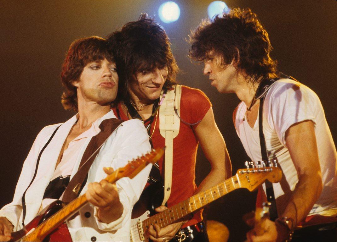 Mick Jagger, Ronnie Wood, and Keith Richards all playing guitars while performing live onstage at the Oshawa Civic Auditorium in 1979.