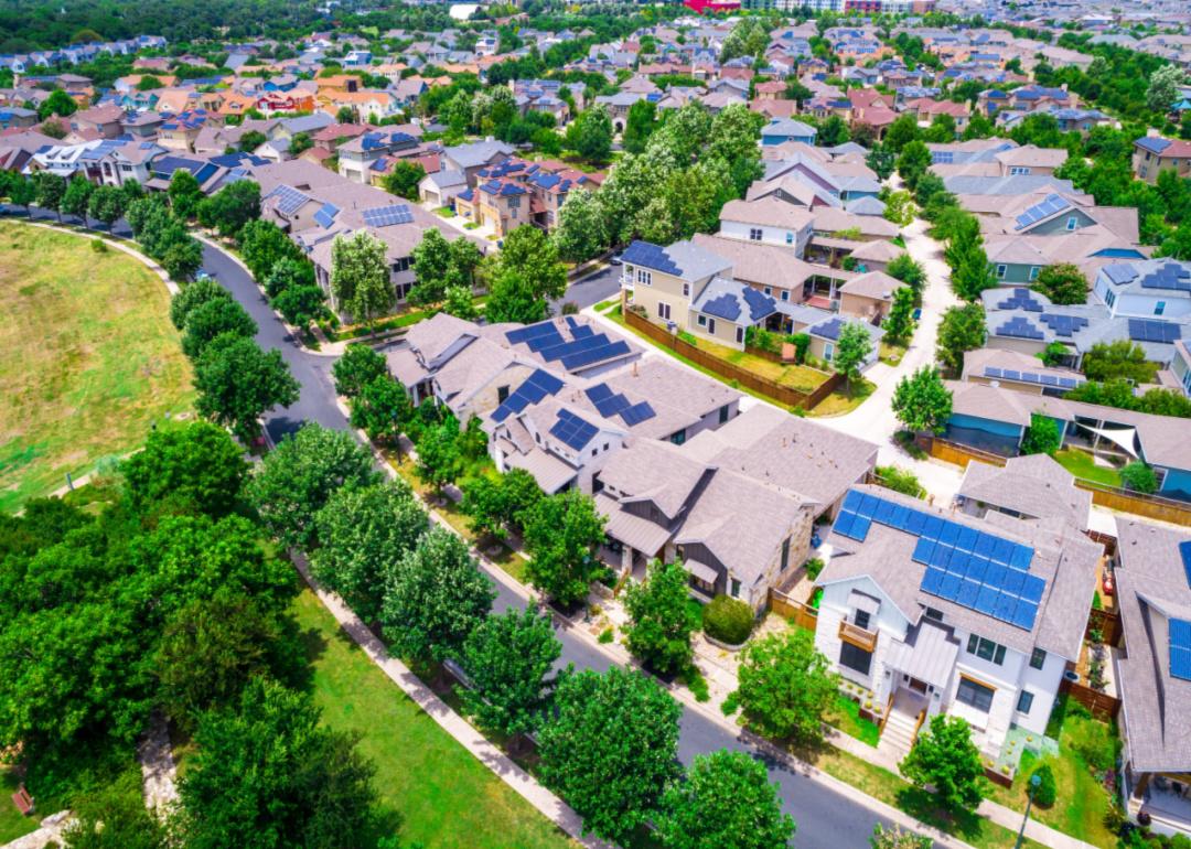 An aerial view of a neighborhood full of solar panels.