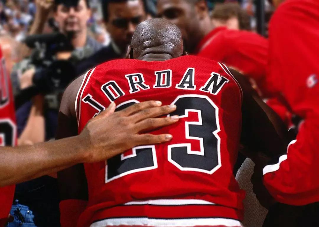 Michael Jordan photographed from behind in a huddle with the legendary 1990s Chicago Bulls in the miniseries 'The Last Dance.'