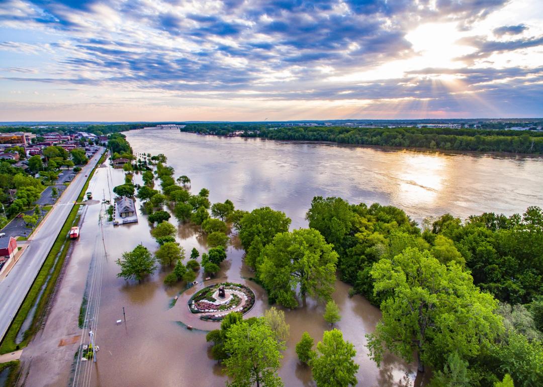 An aerial view of Mississippi River flooding near a road and in forested areas.