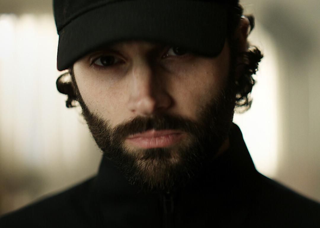 Actor Penn Badgley in wears a black baseball hat and turtleneck in Season 4 of the Netflix series 'You.'