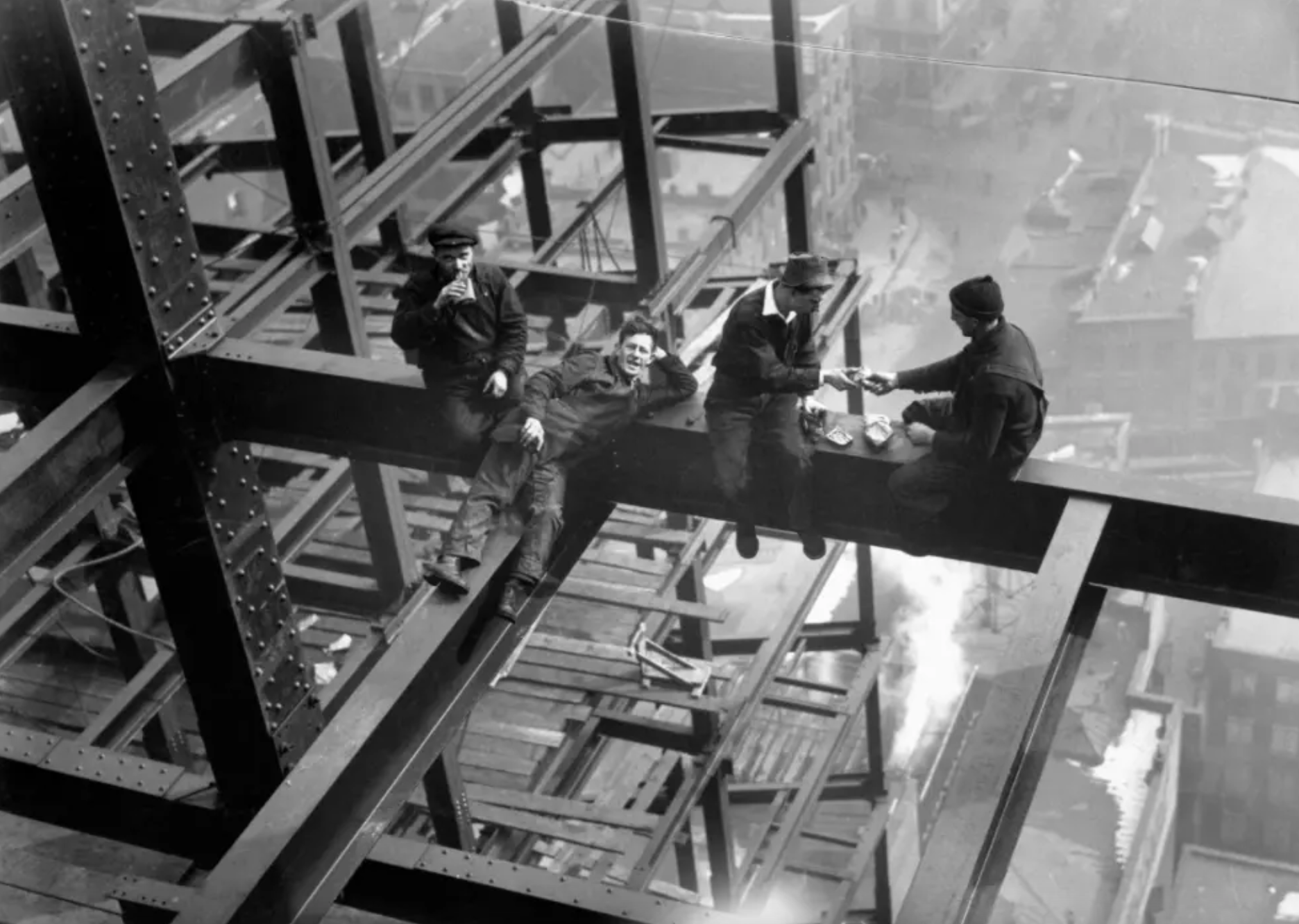 Workers eat lunch atop beam of skyscraper under construction