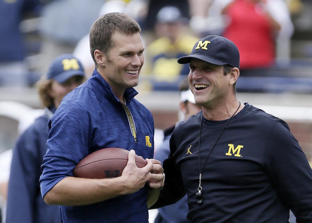 Quarterback Tom Brady laughs with head coach Jim Harbaugh of the Michigan Wolverines.