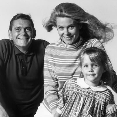 Actors Dick York, Elizabeth Montgomery, and Erin Murphy pose on a bicycle in a promotional portrait for the television series 'Bewitched.'