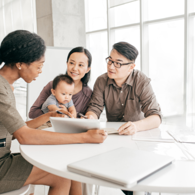 A young family sits at a table working with a financial consultant
