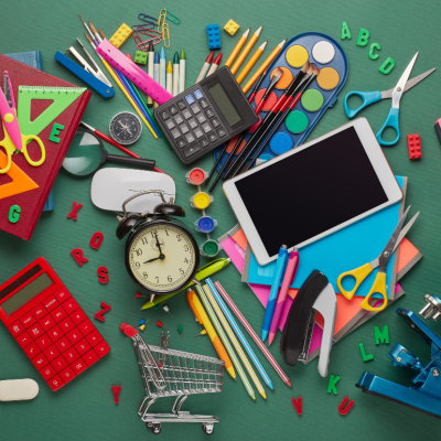 An assortment of school supplies on a green background