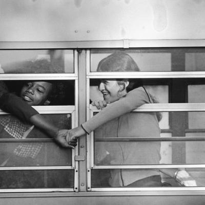 A black student and a white student grasp hands through window as the bus pulled up in front of Charlestown High School in Boston in 1975.