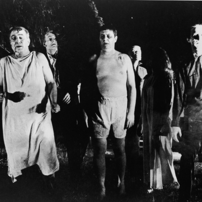 A line of undead 'zombies' walk through a field in the night in a still from the film, 'Night Of The Living Dead,' directed by George Romero, 1968. 