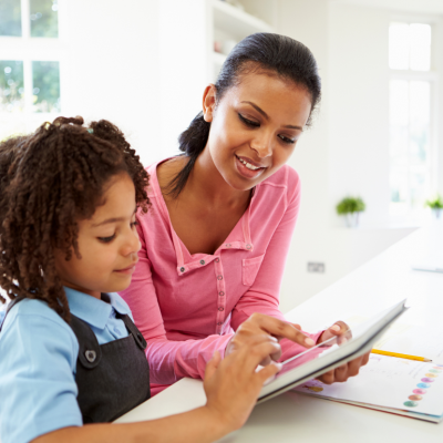 A Black mother teaching her daughter financial literacy.