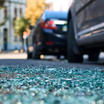 Shards of glass on the street after a car crash in a city.